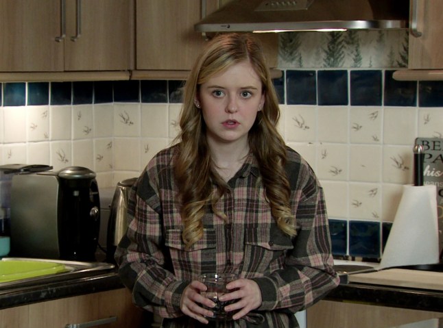 Summer holds a glass of water in Coronation Street