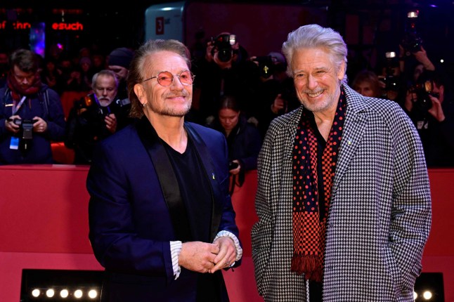 Irish singer and U2 frontman Bono (L) and Irish musician and U2 bassist Adam Clayton pose during a photo call prior to the premiere of the film 'Kiss the Future' presented as Berlinale Special at the Berlinale, Europe's first major film festival of the year, in Berlin on February 19, 2023. (Photo by John MACDOUGALL / AFP) (Photo by JOHN MACDOUGALL/AFP via Getty Images)