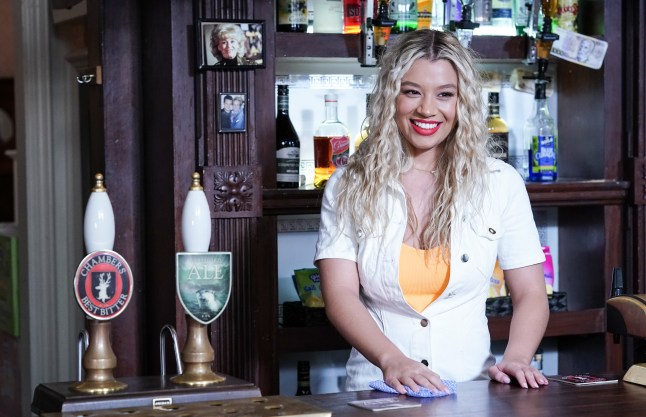 Molly Rainford as Gina Knight in EastEnders, behind the Queen Vic bar