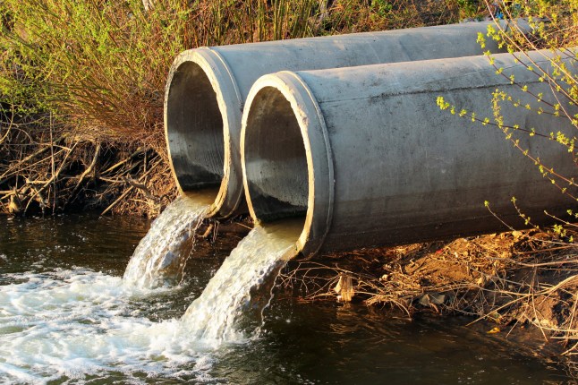 Discharge of sewage into a river; Shutterstock ID 1074943199; purchase_order: -; job: -; client: -; other: -