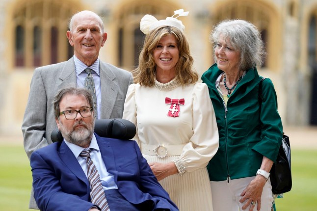 English broadcaster and journalist Kate Garraway stands with her husband Derek Draper and her parents Gordon and Marilyn Garraway, as she poses with their medal after being appointed a Member of the Order of the British Empire (MBE), following an investiture ceremony at Windsor Castle, in Windsor on June 28, 2023. (Photo by Andrew Matthews / POOL / AFP) (Photo by ANDREW MATTHEWS/POOL/AFP via Getty Images)