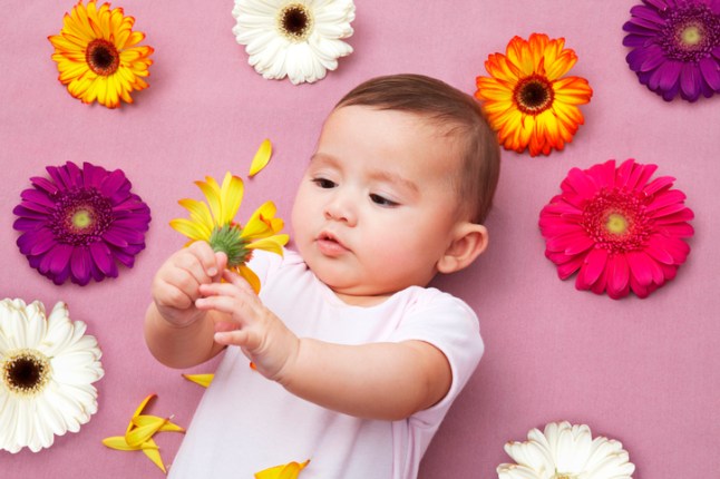 Baby girl holding flower