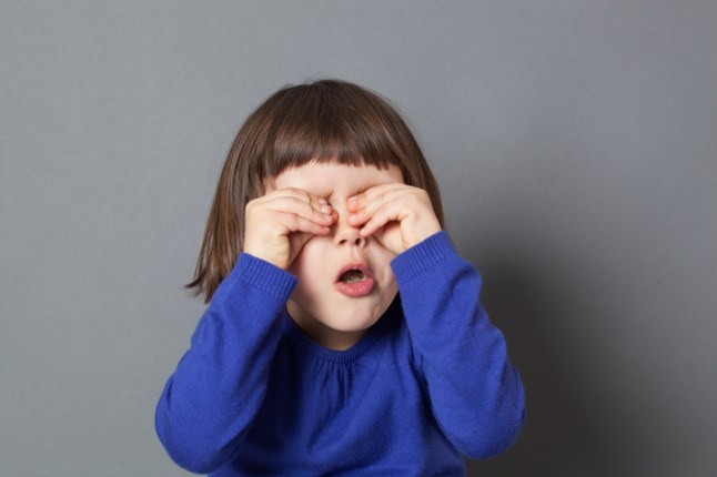 cheerful preschooler hiding eyes for fun peek-a-boo game