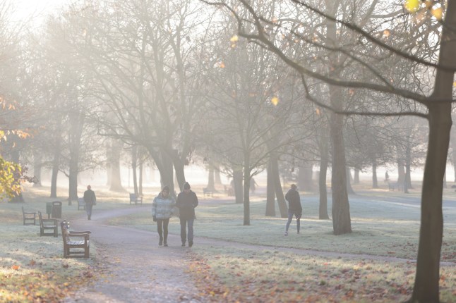 ?? Licensed to London News Pictures. 06/12/2023. London, UK. Members of the public walk through frost, mist and Autumnal colors in the early morning sunshine in Queens Park, north west London. Large parts of the UK are experiencing freezing temperatures and snow expected in areas. Photo credit: Ben Cawthra/LNP