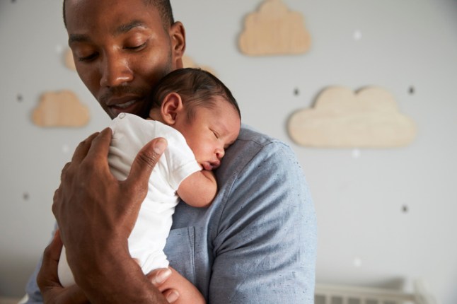 Father Holding Newborn Baby Son In Nursery