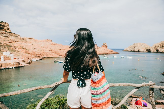 beautiful latina standing in a balcony in Cala Morell,Minorca,Balearic islands; Spain