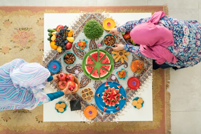 Two females preparing food decorated table