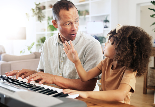 Piano, learning and girl with grandfather in home, playing or bonding together. Wow surprise, education and shocked grandpa teaching kid how to play musical instrument, acoustic and electric keyboard