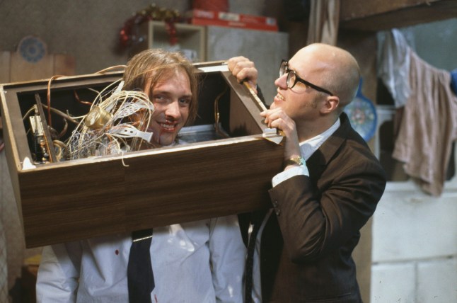 Comic actors Rik Mayall (left) and Adrian Edmondson destroying a television set in a scene from episode 'Culture' of the BBC television sitcom 'Bottom', May 17th 1992. (Photo by Don Smith/Radio Times/Getty Images)