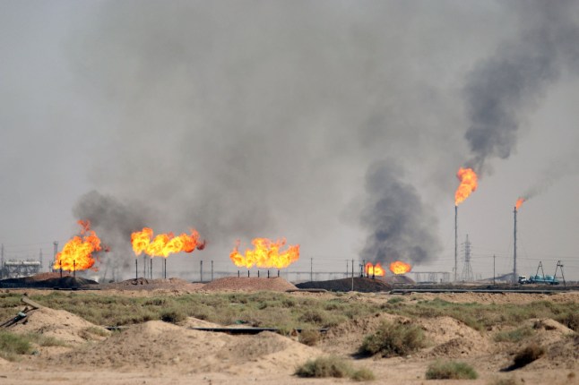 A picture taken on October 23, 2017 shows gas flares burning at the North Rumaila natural gas field, north of the southern Iraqi port of Basra. (Photo by HAIDAR MOHAMMED ALI / AFP) / "The erroneous mention[s] appearing in the metadata of this photo by HAIDAR MOHAMMED ALI has been modified in AFP systems in the following manner: [North Rumaila natural gas field] instead of [Bin Omar natural gas station]. Please immediately remove the erroneous mention[s] from all your online services and delete it (them) from your servers. If you have been authorized by AFP to distribute it (them) to third parties, please ensure that the same actions are carried out by them. Failure to promptly comply with these instructions will entail liability on your part for any continued or post notification usage. Therefore we thank you very much for all your attention and prompt action. We are sorry for the inconvenience this notification may cause and remain at your disposal for any further information you may require." (Photo by HAIDAR MOHAMMED ALI/AFP via Getty Images)