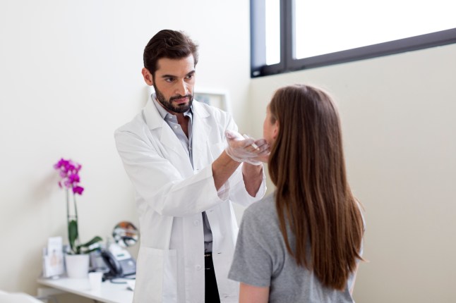 Cosmetic surgeon marking patients face for surgery