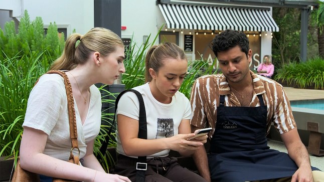 Holly shows Haz and Mackenzie something on her phone in Neighbours