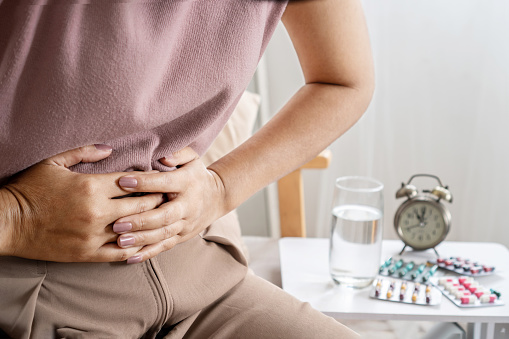 irritable bowel syndrome IBS concept with woman hand holding a stomachache having problems with the digestive system