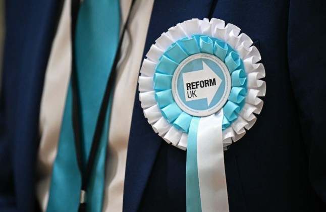 Reform UK rosette pinned to a jacket