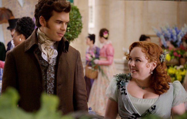 Bridgerton. (L to R) Luke Newton as Colin Bridgerton, Nicola Coughlan as Penelope Featherington