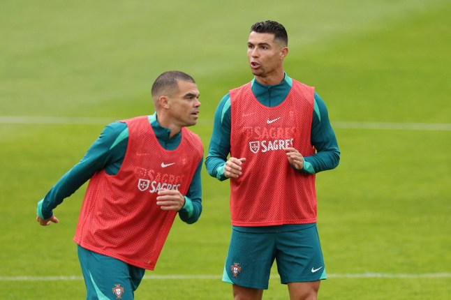 GUETERSLOH, GERMANY - JUNE 14: Pepe and Cristiano Ronaldo of Portugal react during the Portugal Public Training Session at Heidewaldstadion on June 14, 2024 in Guetersloh, Germany. (Photo by Kevin C. Cox/Getty Images)