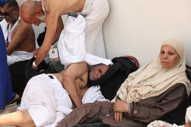 A man effected by the scorching heat rests as Muslim pilgrims arrive to perform the symbolic 'stoning of the devil' ritual as part of the hajj pilgrimage in Mina, near Saudi Arabia's holy city of Mecca, on June 16, 2024. Pilgrims perform the last major ritual of the hajj, the "stoning of the devil", in western Saudi Arabia on June 16, as Muslims the world over celebrate the Eid al-Adha holiday. (Photo by Fadel Senna / AFP) (Photo by FADEL SENNA/AFP via Getty Images)