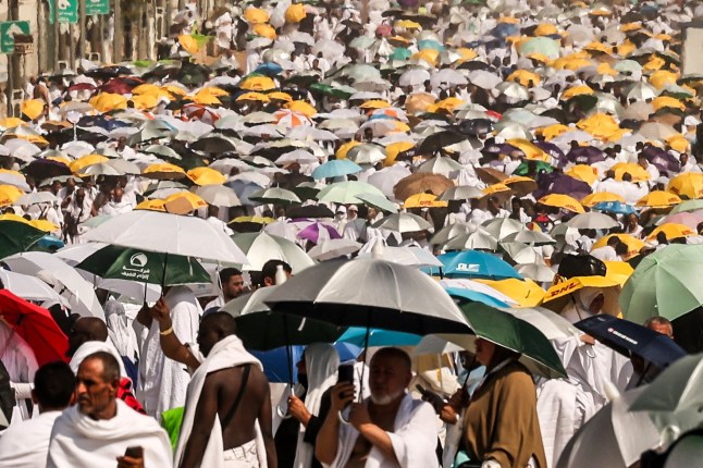 TOPSHOT - Muslim pilgrims use umbrellas to shade themselves from the sun as they arrive at the base of Mount Arafat, also known as Jabal al-Rahma or Mount of Mercy, during the annual hajj pilgrimage on June 15, 2024. Friends and family searched for missing hajj pilgrims on June 19 as the death toll at the annual rituals, which were carried out in scorching heat, surged past 900. (Photo by Fadel SENNA / AFP) (Photo by FADEL SENNA/AFP via Getty Images)