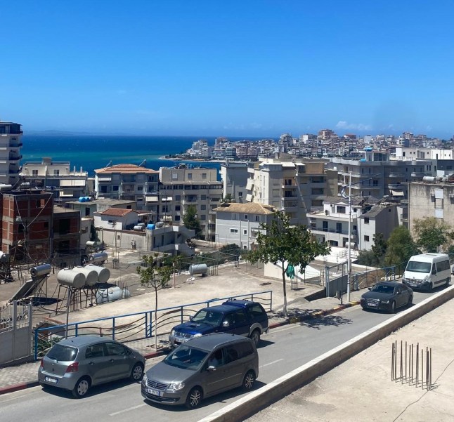 A view of Sarande bay in Albania, showing apartment blocks and cars