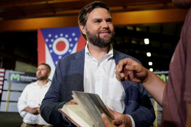 FILE - J.D. Vance, the venture capitalist and author of "Hillbilly Elegy," holds his book as he speaks with supporters after a rally on July 1, 2021, in Middletown, Ohio, where he announced he is joining the crowded Republican race for the Ohio U.S. Senate seat. Sen. Vance, R-Ohio, sharply criticized Donald Trump during the 2016 election cycle, before changing course and embracing the former president. Vance is now one of Trump's fiercest allies and defenders and among those short-listed to be Trump's vice presidential pick. (AP Photo/Jeff Dean, File)