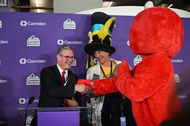 Britain's Labour Party leader Keir Starmer is congratulated by fellow candidates Bobby 'Elmo' Smith (R) and Nick 'The Flying Brick' Delves (2ndR) after winning his seat for Holborn and St Pancras at the Camden Council count centre in London early on July 5, 2024 after polls closed in Britain's general election. Britain's main opposition Labour party looks set for a landslide election win, exit polls indicated, with Keir Starmer replacing Rishi Sunak as prime minister, ending 14 years of Conservative rule. (Photo by JUSTIN TALLIS / AFP) (Photo by JUSTIN TALLIS/AFP via Getty Images)