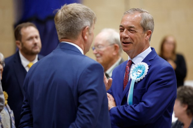 Britain's Reform UK Party Leader Nigel Farage speaks to a person as the counting of votes continues during the UK election in Clacton-on-Sea, Britain, July 5, 2024. REUTERS/Clodagh Kilcoyne