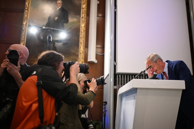 Nigel Farage, Reform UK leader and new MP for Clacton, reacts as a protester interrupts his presentation of the programme of newly elected Reform UK MPs in London on July 5, 2024, a day after Britain held a general election. As of 1200 GMT on Friday, the Labour party had won 412 seats in the House of Commons with only two results left to declare, giving it a majority of more than 170. The Conservative Party won just 121 seats -- a record low -- with the right-wing vote apparently spliced by Nigel Farage's anti-immigration Reform UK party. (Photo by Oli SCARFF / AFP) (Photo by OLI SCARFF/AFP via Getty Images)