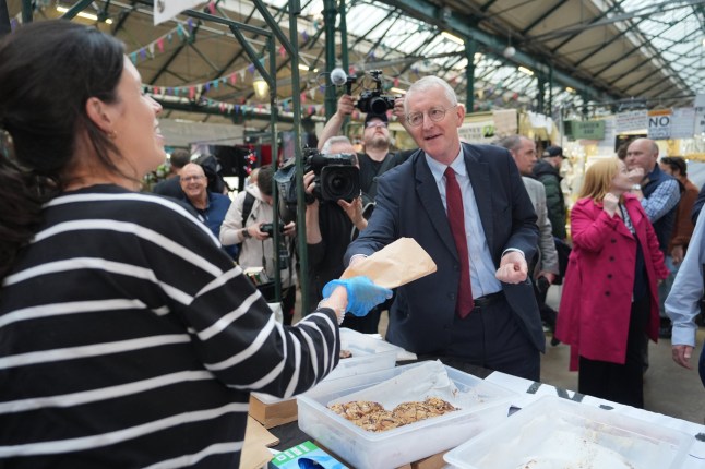 Northern Ireland Secretary Hilary Benn buys cookies during a visit to St George's Market in Belfast, following the Labour Party's victory in the 2024 General election. Picture date: Sunday July 7, 2024. PA Photo. See PA story POLITICS Labour. Photo credit should read: Niall Carson/PA Wire