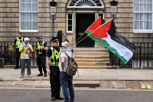 A protester holds a Palestinian flags outside Bute House as Britain's Prime Minister Keir Starmer meets Scotland's First Minister John Swinney at Bute House in Edinburgh, Scotland, Britain July 7, 2024. REUTERS/Lesley Martin