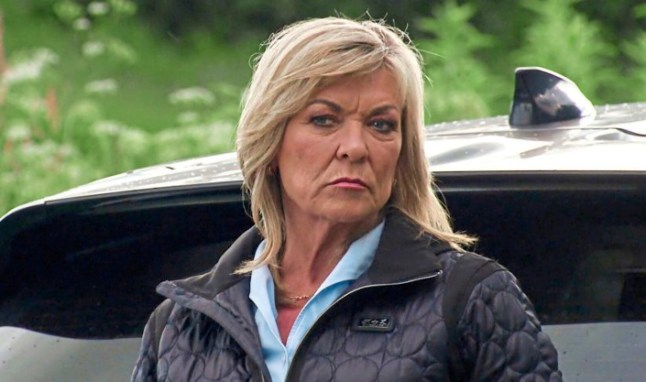 Kim Tate looks angry outside a car in Emmerdale