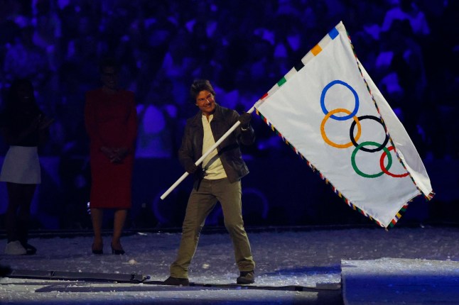 Paris 2024 Olympics - Ceremonies - Paris 2024 Closing Ceremony - Stade de France, Saint-Denis, France - August 11, 2024. Actor Tom Cruise holds the Olympics flag during the closing ceremony. REUTERS/Albert Gea