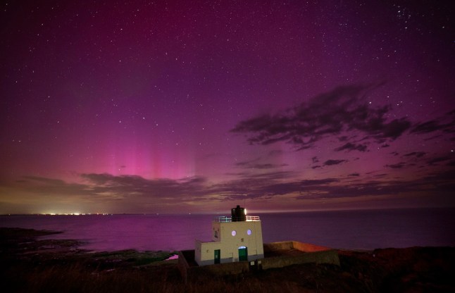 The aurora borealis, also known as the northern lights, appears over Bamburgh Lighthouse, in Northumberland on the North East coast of England. Picture date: Monday August 12, 2024. PA Photo. Photo credit should read: Owen Humphreys/PA Wire