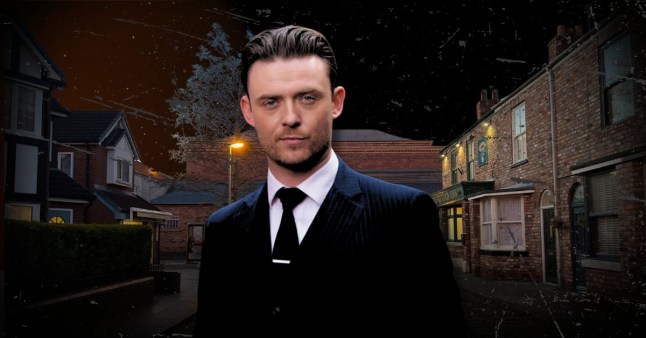 Joel Deering stood in the centre of a dark Coronation Street, wearing a suit