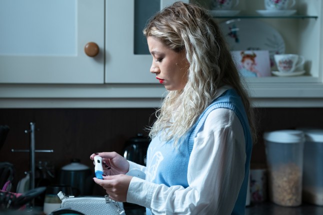 Anna looks at a pregnancy test in EastEnders