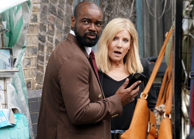 Junior Knight and Cindy Beale looking surprised outside the cafe in EastEnders