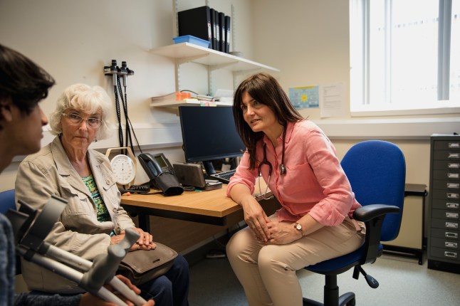 A GP talking to patients in a surgery.