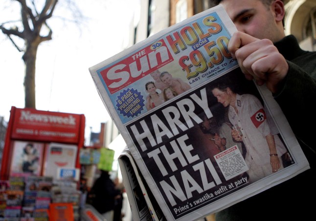 (FILES) In this file photo taken on January 13, 2005 A man reads the newspaper "The Sun" in London 13 January, 2005 with a headline about Prince Harry wearing a Nazi uniform at a costume party. - Scarred by the death of his mother, Prince Harry has struggled in the royal limelight for much of his life, and his fears for wife Meghan have now put him at loggerheads with his family. The younger son of the heir to the throne Prince Charles and the late Diana, princess of Wales, Harry, now 36, earned a reputation as a young playboy desperate to escape the royal straightjacket. Having left his wild-child ways behind him, the prince appeared to have found his place in the family with Meghan and son Archie. (Photo by Jim WATSON / AFP) (Photo by JIM WATSON/AFP via Getty Images)