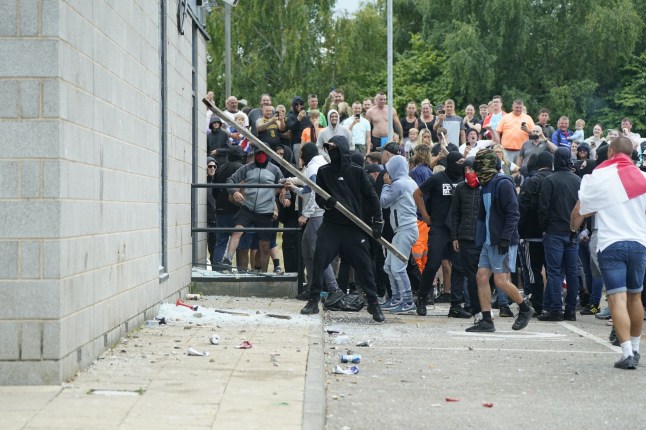 File photo dated 04/08/24 of Thomas Birley (centre right, red scarf covering face) in the midst as windows are being smashed as trouble flares during an anti-immigration protest outside the Holiday Inn Express in Rotherham, South Yorkshire. Thomas Birley has been handed the longest prison sentence so far following the rioting in early August after he was jailed at Sheffield Crown Court for nine years for his role in the violence outside a hotel housing hundreds of asylum seekers in Rotherham. Issue date: Friday September 6, 2024. PA Photo. See PA story COURTS Southport. Photo credit should read: Danny Lawson/PA Wire