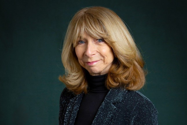 Helen Worth, who plays Gail Platt in Coronation Street, smiling while wearing a grey blazer and black turtleneck