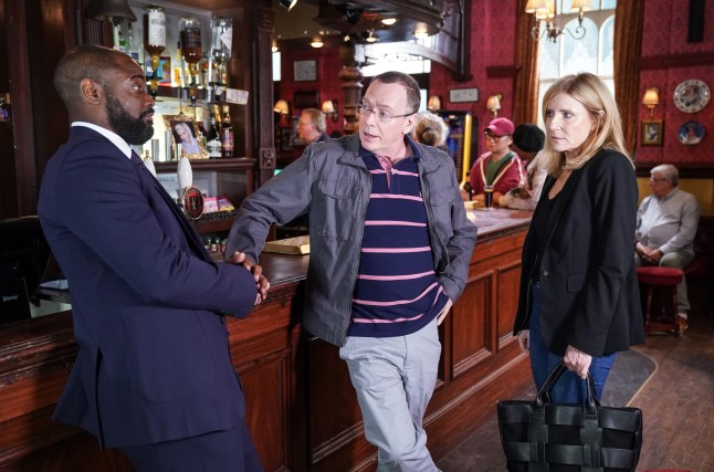 Junior, Ian and Cindy stand at the bar in the Queen Vic in EastEnders