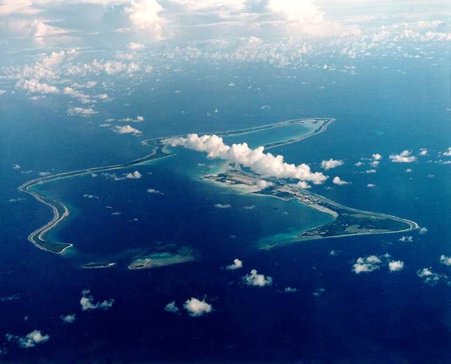 Aerial image of the Chagos Islands in Mauritius, showing white clouds above an island in the deep blue ocean