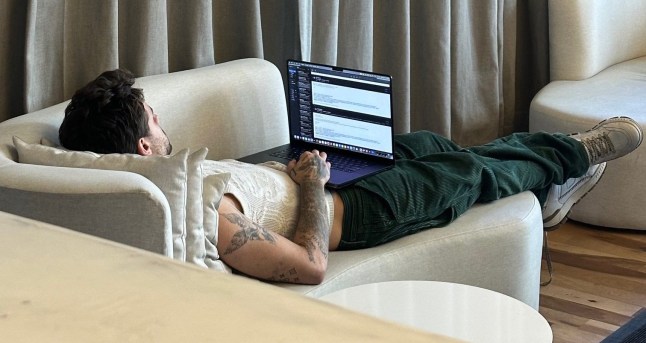 Liam Payne pictured laying on a couch on his laptop by someone staying at the same hotel in Buenos Aires, Argentina. CasaSur Palermo Hotel