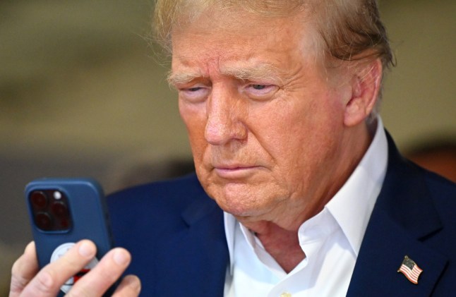 MIAMI, FLORIDA - MAY 05: Donald Trump talks on the phone in the McLaren garage prior to the F1 Grand Prix of Miami at Miami International Autodrome on May 05, 2024 in Miami, Florida. (Photo by Clive Mason/Getty Images)