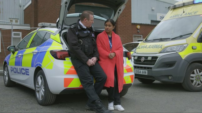 Rob and Ruhma speak outside a police car in Doctors