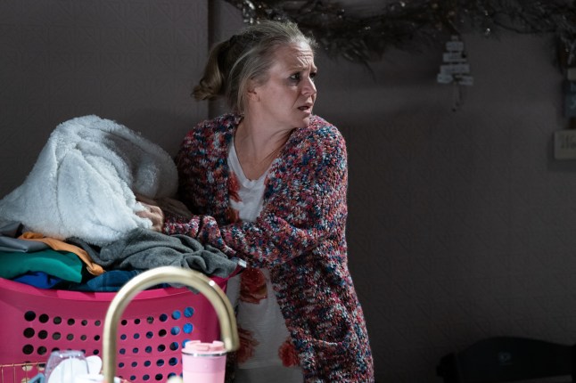 Linda Carter next to a washing basket in EastEnders