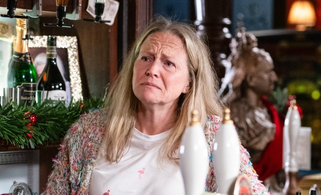 Kellie Bright as EastEnders character Linda Carter, fighting tears behind the Queen Vic bar