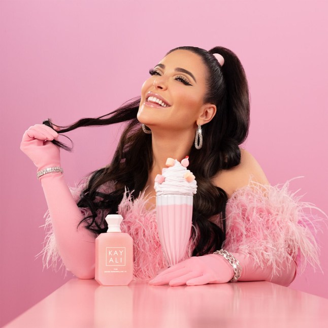 Image of Mona Kattan, posing with her latest fragrance - Yum Boujee Marshmallow.