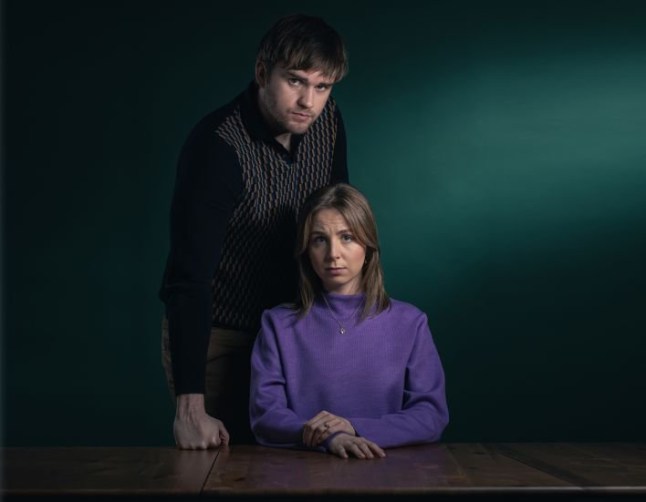 An Emmerdale press shot of Tom King (James Chase) looming over Belle Dingle (Eden Taylor-Draper)