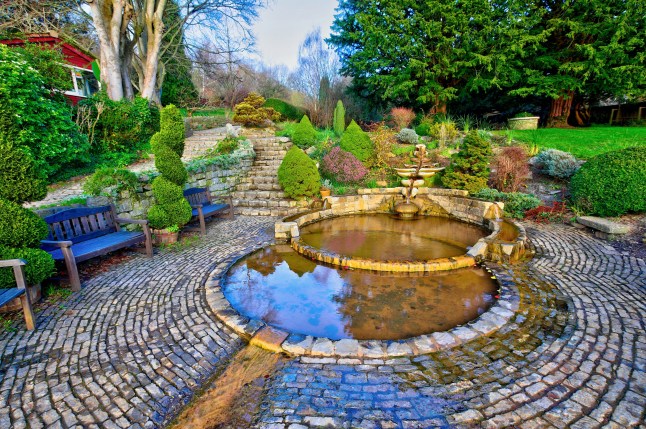 Golden hour view of the Vesica Fountain in the Chalice Well park, also known as the Red Spring,