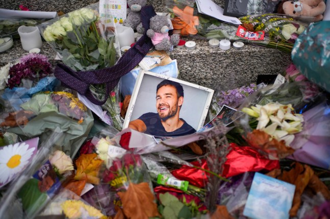 WOLVERHAMPTON, ENGLAND - NOVEMBER 05: Flowers and tributes for One Driection's Liam Payne are left next to the Lady Wulfrun statue outside St. Peter's Collegiate Church on November 05, 2024 in Wolverhampton, England. Fans of Liam Payne are petitioning for a permanent memorial to be erected in Wolverhampton, the hometown of the former One Direction star. Payne tragically fell to his death from a hotel balcony in Buenos Aires on October 16. (Photo by Christopher Furlong/Getty Images)